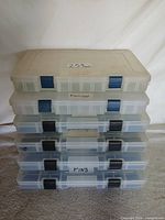 Stack of six clear plastic containers showing blue latches and labels