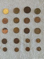 Full view of 20 coins laid out in five rows on fabric background