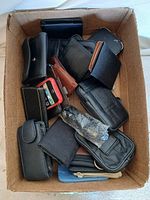 Box containing assorted phone cases and holsters