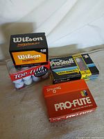 Four boxed packs of golf balls grouped together