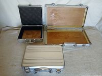 Three aluminium cases shown closed and open to illustrate sizes and exteriors