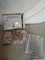 Entire kit laid out: box, booklet, sealed toys, papers