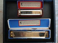 Both harmonicas inside their original boxes