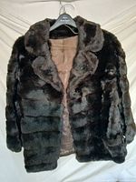 Front view of mahogany-brown faux fur coat on hanger
