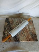 Marble rolling pin resting on granite pastry board