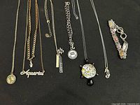 Group shot of all eight jewelry pieces on black background