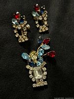 brooch and both earrings front view on black background