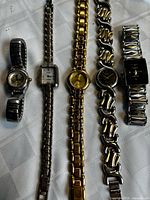All five wristwatches laid out on table