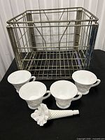 Overall lot showing four milk glass cups, hobnail cornucopia vase, and vintage metal crate