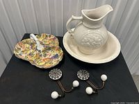 Group shot showing wash pitcher with basin, divided fruit motif dish, and two wall hooks