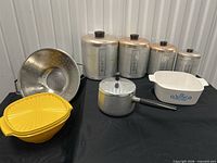 Group shot showing all items: canister set, saucepan, colander, Tupperware strainer, Pyrex casserole