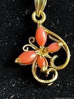 Close-up of butterfly pendant showing cabochons and gold-tone scroll work