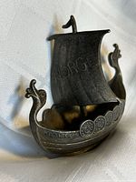 Front three-quarter view of pewter Viking ship showing sail marked "Norge," dragon heads and shield details