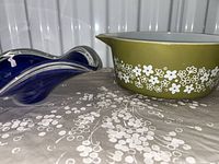 Pyrex casserole bowl and blue wave edge art glass bowl side by side