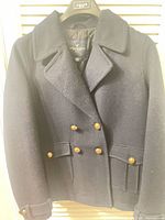 Front view of navy double-breasted peacoat with buttons and pockets