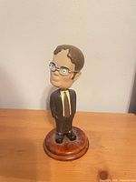 Front view of Dwight Schrute bobblehead on wood-tone base