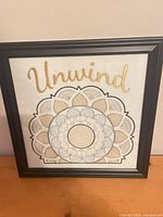 Front view of framed cross-stitch art showing full design and text