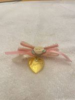 Front view showing pink/cream ribbon bow, ivory rosette, and gold-tone heart marked "Mother"