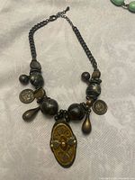 Full view of necklace showing chain, beads, pendant and charms