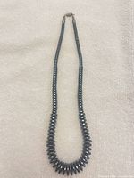 Full view of hematite disc bead necklace laid flat