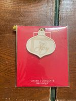 Front view of ivory porcelain ornament on red Lenox backing card