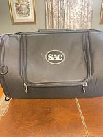 Front view showing SAC logo, front pocket and zippers
