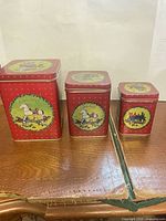 Front view of all three rectangular Christmas tins with lids