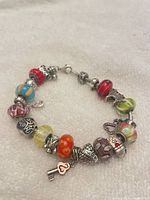 Full view of silver tone charm bracelet with multicolor glass beads