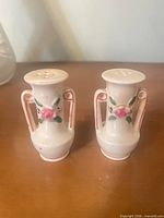 front view of both ceramic shakers showing floral design and handles