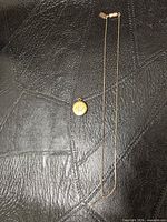 Full view of chain and locket on black surface