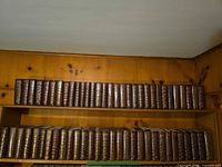 Two shelves filled with many matching Reader's Digest Condensed Books hardcover volumes
