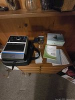Kodak EK6 instant camera, Canon camera with charger, case, manuals, CD and box on tabletop