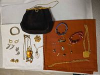 Overall lot layout showing all jewellery and evening bag