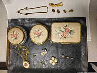 Group shot showing all trinket boxes, necklaces, pins and earrings together