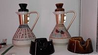 Front view of both decanters with stoppers and both ashtrays