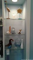 Full cabinet view showing all decorative pieces on three glass shelves