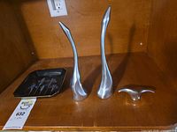 Three pewter sculptures and iris plate on shelf