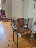 Both porcelain lamps on cane-top table