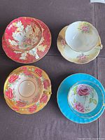 Four teacup and saucer sets displayed