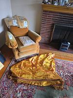 Armchair, three packaged throw covers on seat and patterned valance on floor