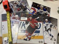 Five autographed photos front view with tape for scale