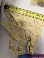 Both floral dog bandanas showing fabric pattern and elastic neck, measuring tape indicates size