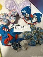 Group of six fabric elastic hair bows with Lot# card visible