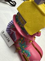 Exterior side view of pink boot playset with yellow roof and floral trims