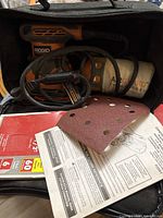 Sander in case with cord, AirGuard dust bag, sanding sheets and paperwork