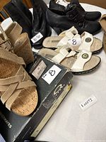 Group shot showing five pairs of shoes and boots on table