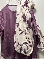 Mauve top on hanger with cream floral pants draped
