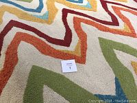 Close-up photo showing the thick plush texture and multi-color zigzag pattern of the outdoor rug.