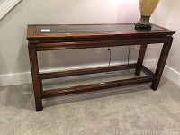 Front view of cherry wood sofa table with glass shelves, showing overall structure and condition.