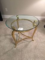 Round glass top on brass frame end table showing full top view with glass on.